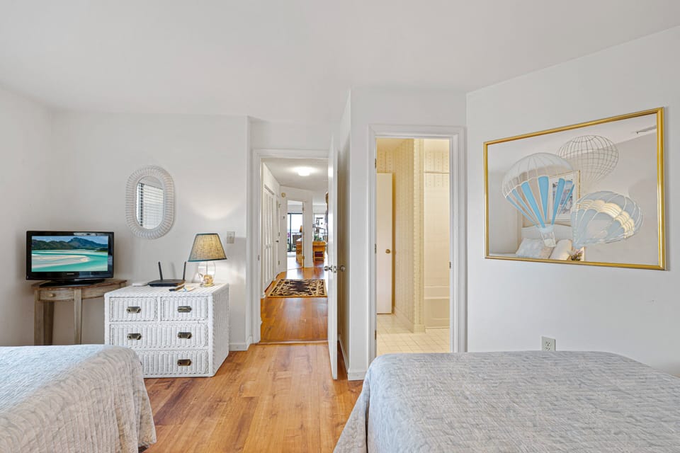Coastal furnishings, a TV, and convenient access to the nearby full bathroom make it an ideal space for children, friends, or another couple.