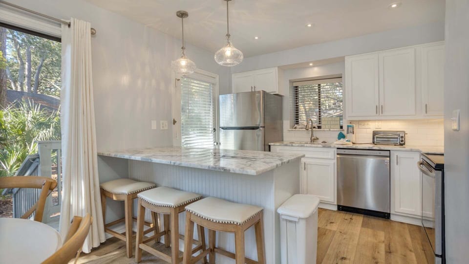 A spacious breakfast bar with seating invites casual meals and conversation, while recessed lighting keeps the space bright and welcoming.