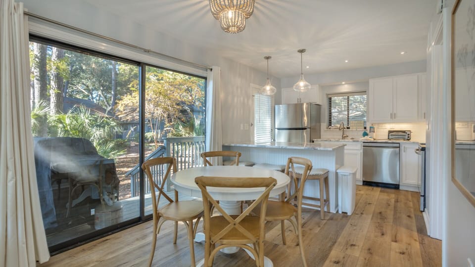 Natural light pours in through the sliding glass doors, offering easy access to the deck and wooded views beyond.