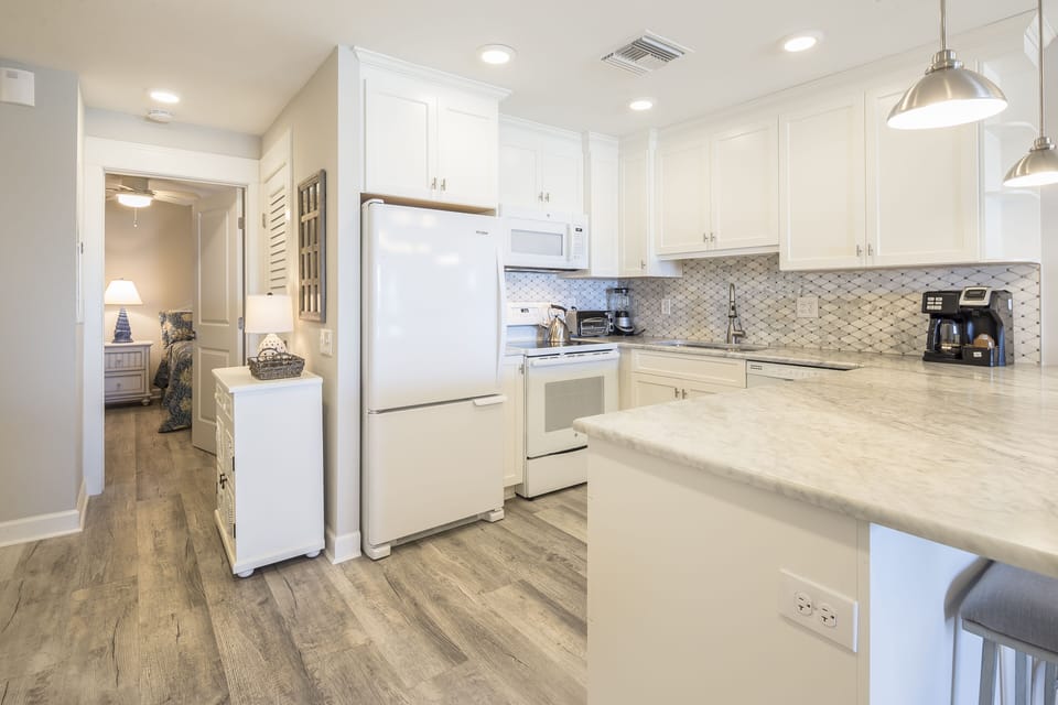 Bright, updated kitchen with ample counter space, modern appliances, and elegant tile backsplash.
