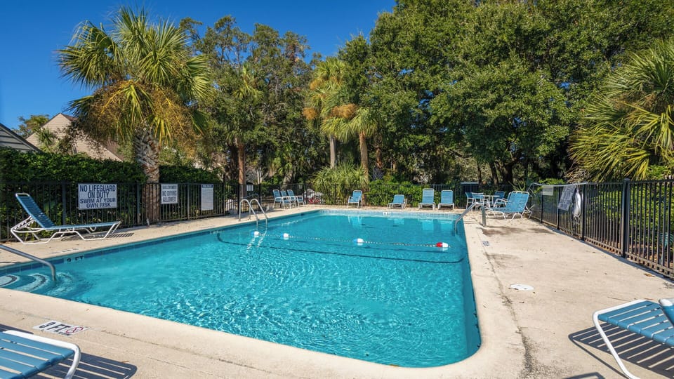 Surrounded by swaying palms and draped oaks, the community pool at Queen's Grant offers a peaceful retreat
