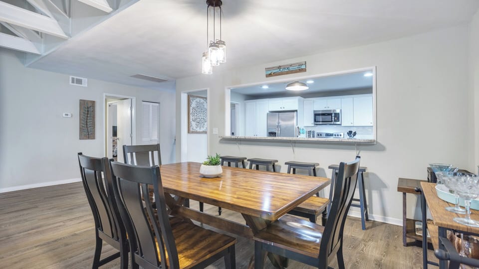 Bar seating adds extra flexibility for casual meals, while the farmhouse-style table is ideal for family dinners.