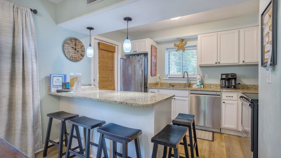 A spacious breakfast bar with seating invites casual meals and conversation, while recessed lighting keeps the space bright and welcoming.