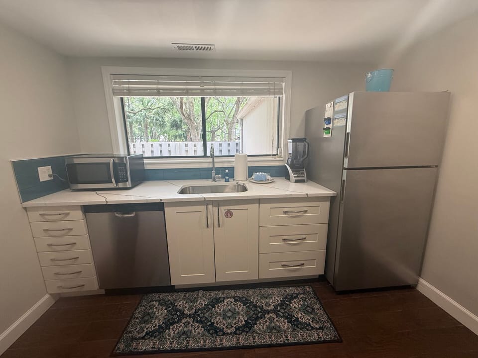 This efficient, well-appointed kitchen is designed for everyday ease, featuring warm wood cabinetry, granite countertops, and a classic tile backsplash.