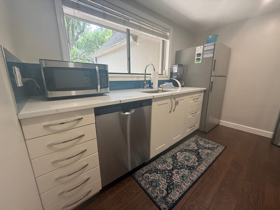 Stainless steel appliances—including a full-size range, microwave, and dishwasher—make meal prep simple.
