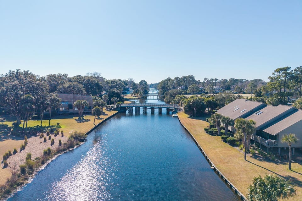 Enjoy peaceful lagoon views surrounded by mature trees and walking paths, with bridges connecting the heart of Palmetto Dunes.