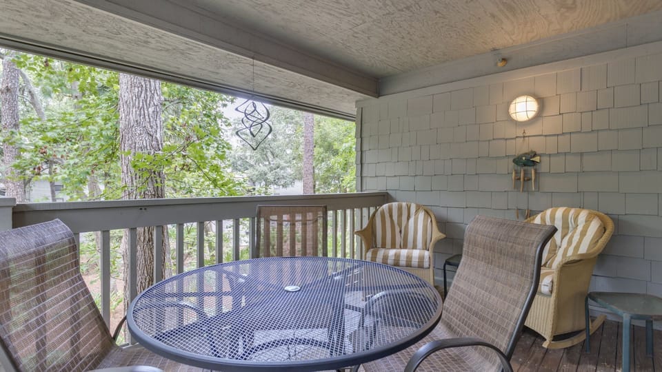 This private balcony offers a peaceful outdoor retreat, framed by mature trees and seasonal blooms that create a natural canopy and serene backdrop.
