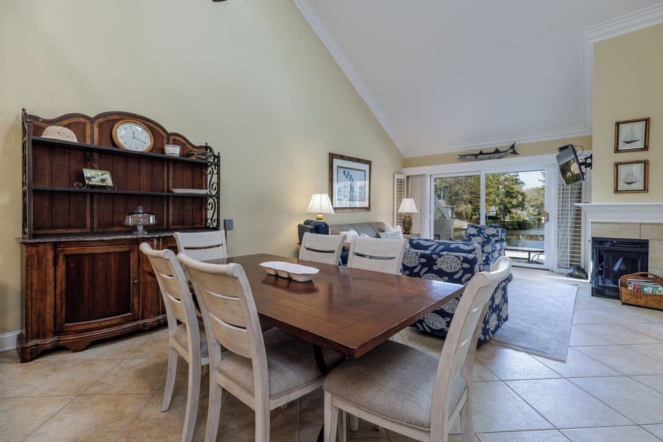 This inviting open-concept living and dining area features vaulted ceilings that create a bright, airy feel and a layout designed for easy gathering.