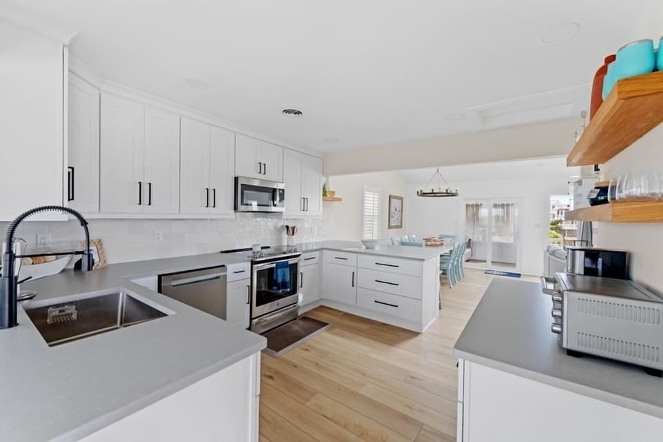 wide open kitchen with over counter lighting, wine fridge and all the pots/pans.