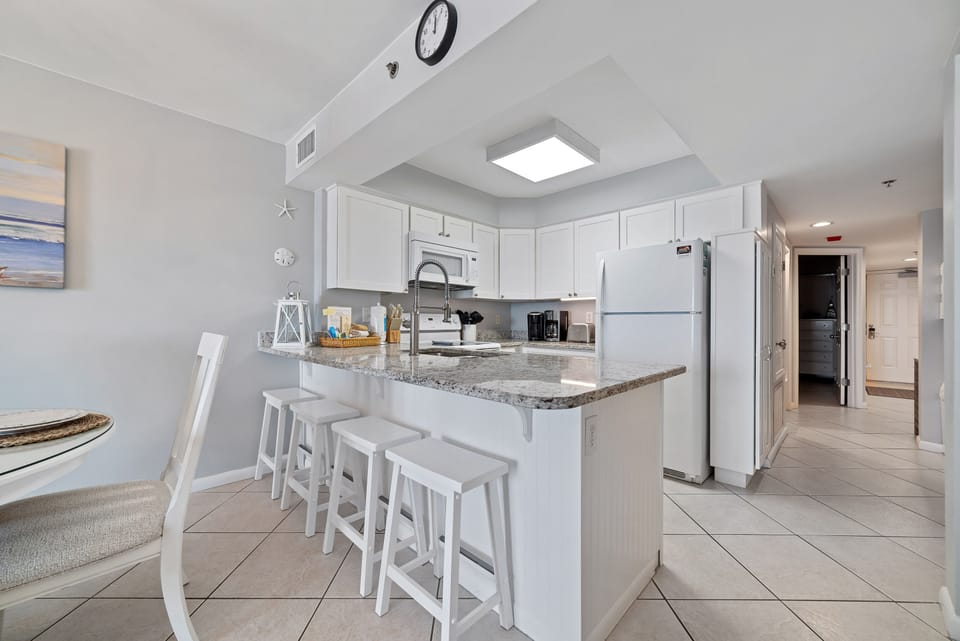 Sleek and sophisticated kitchen featuring a striking island with a stone countertop and comfortable bar stools.