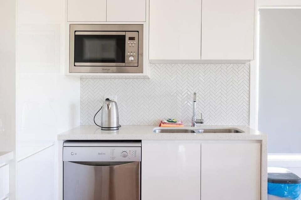 Kitchen with microwave / dishwarsher / stove / hot plate. 
