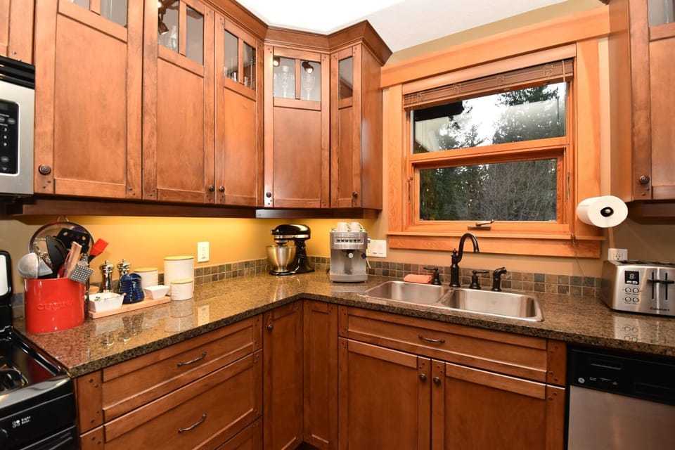 A high functioning kitchen, granite countertops with a west-facing window view.