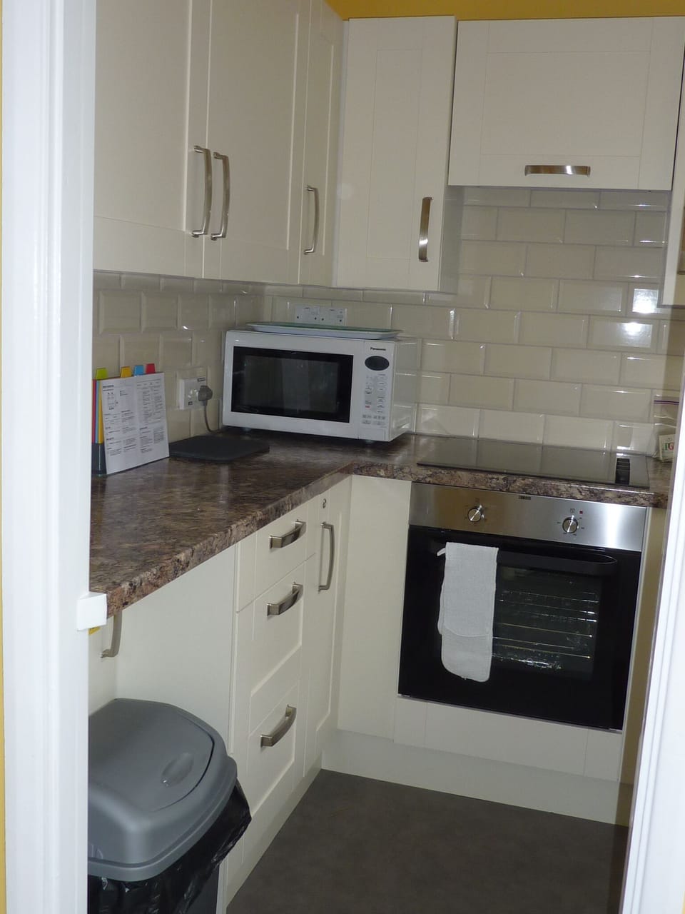 Kitchen area with microwave, toaster, oven, hob, fridge/freezer, sink and kettle