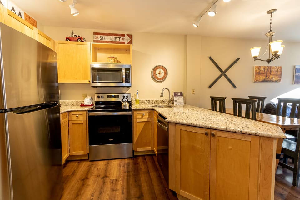 Your fully equipped kitchen features granite counters, stainless appliances, and a breakfast bar perfect for preparing mountain meals together.