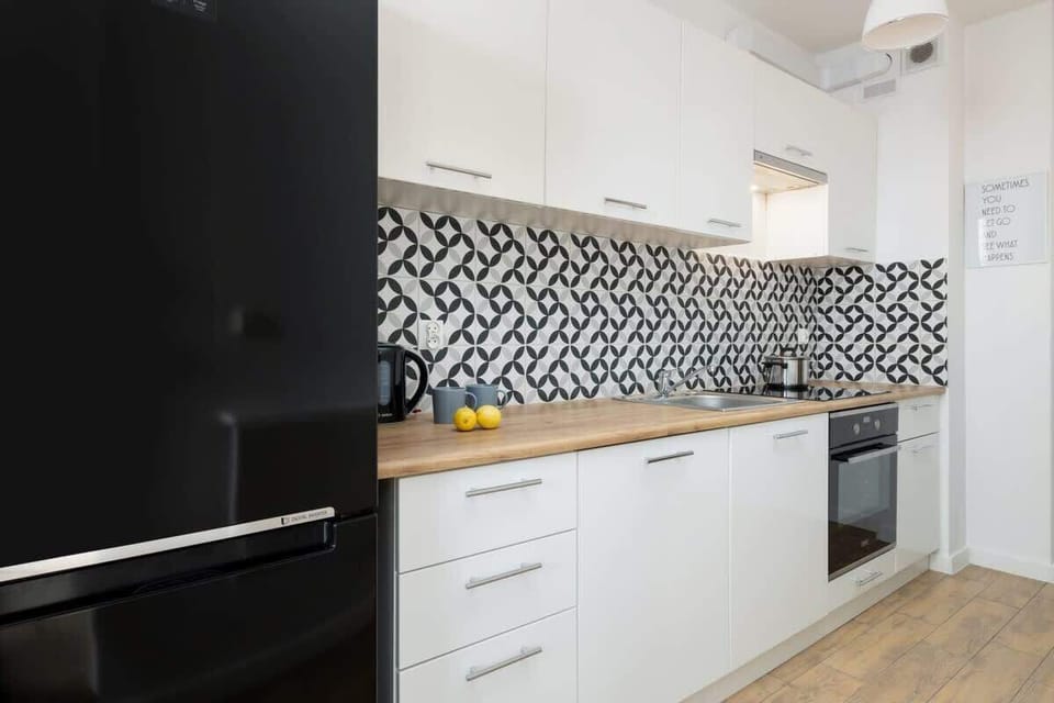 Narrow kitchen with patterned backsplash and minimalist design.