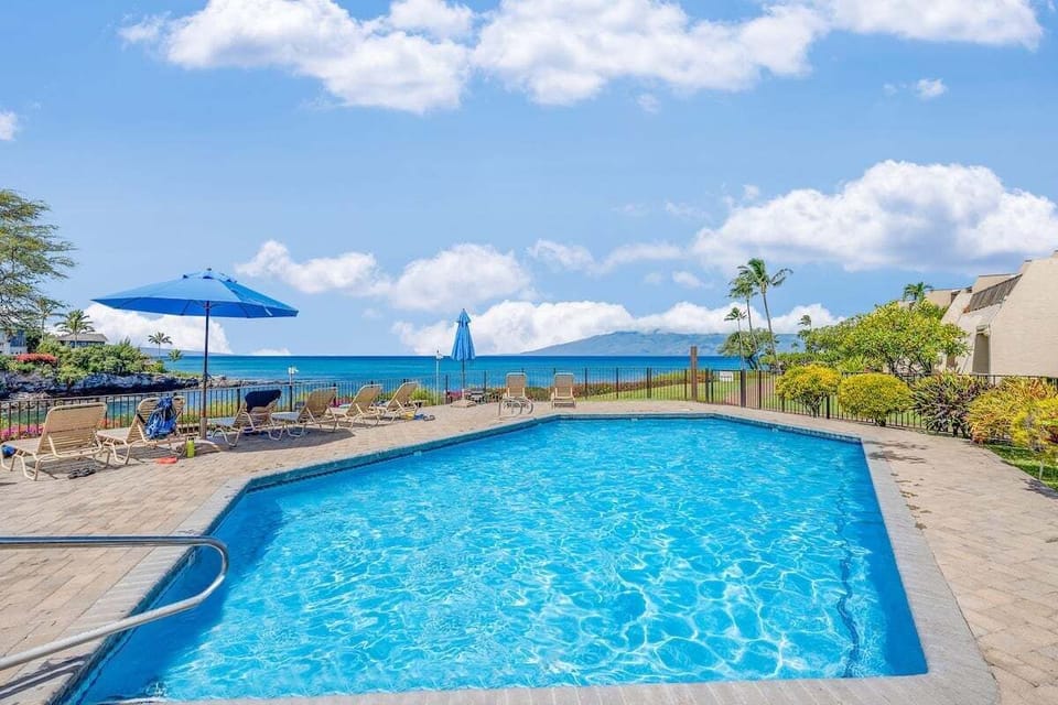 Take a refreshing dip or lounge under a blue umbrella at the ocean-view pool. The expansive deck offers plenty of space to unwind while enjoying the coastal breeze.