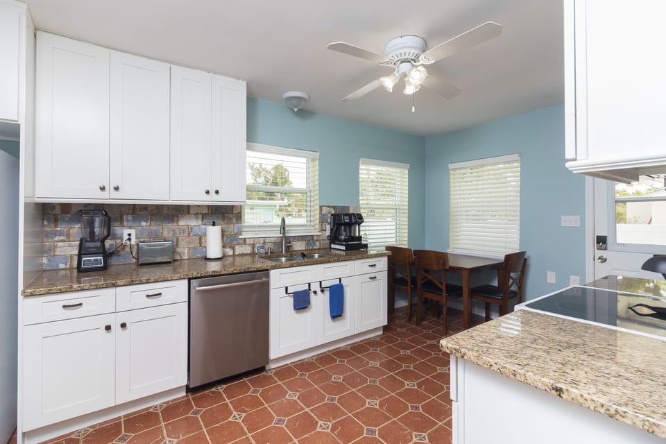 fully stocked kitchen with toaster, blender, pots and pans, spices, coffee maker