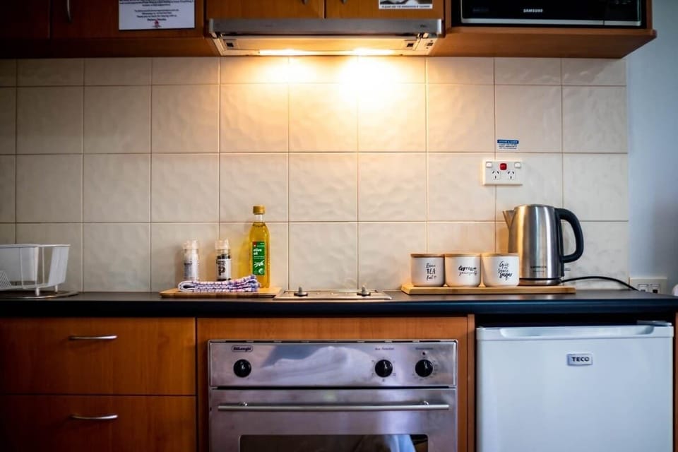 Our well-appointed kitchen is ready for your culinary creations, featuring a convenient oven and stove, a hot water kettle, and oil for cooking needs.