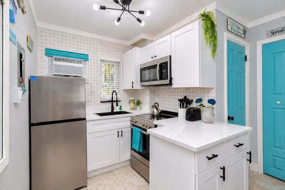 Fully equipped kitchen with a full-size refrigerator, glass-top range/oven, microwave, and toaster — everything you need to whip up breakfast or beach snacks without leaving the resort.