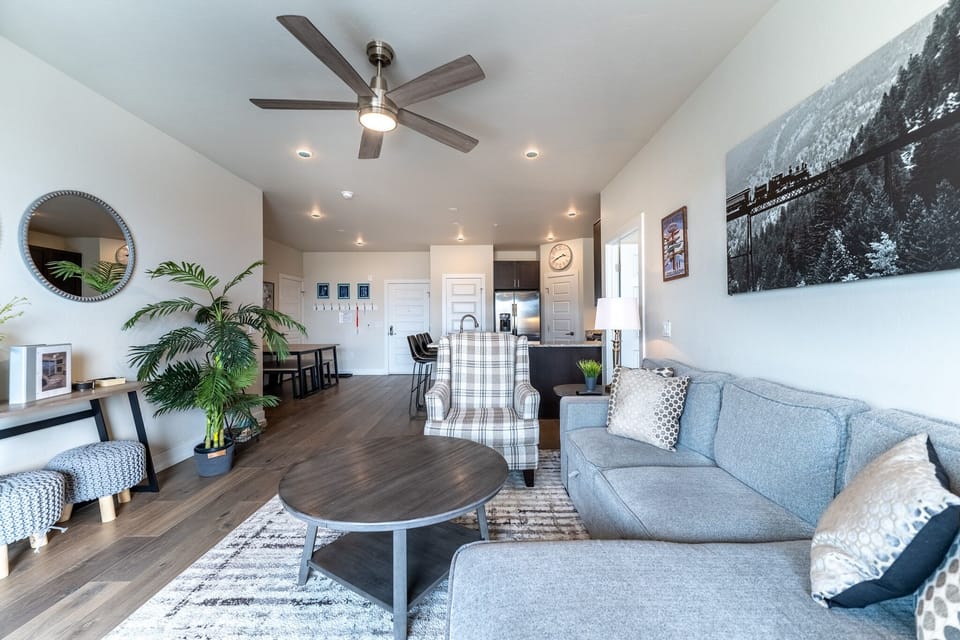 Unwind in your open-concept living space with plush seating, modern décor, and mountain artwork creating a serene retreat.