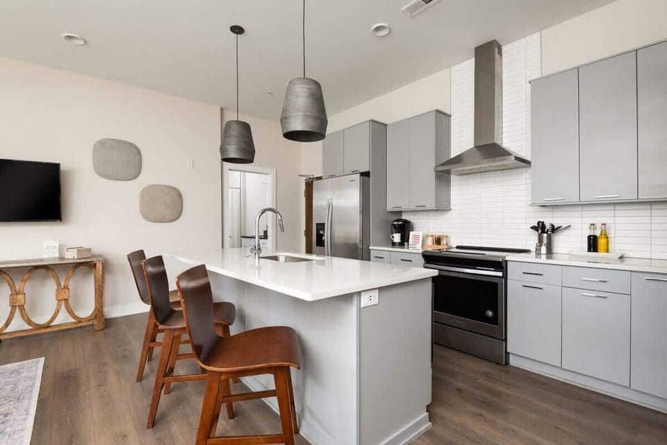 Contemporary kitchen featuring stainless steel appliances, spacious island, and bar seating.