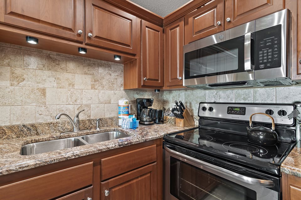 Fully equipped kitchen with stove, microwave, dishwasher, and utensils.