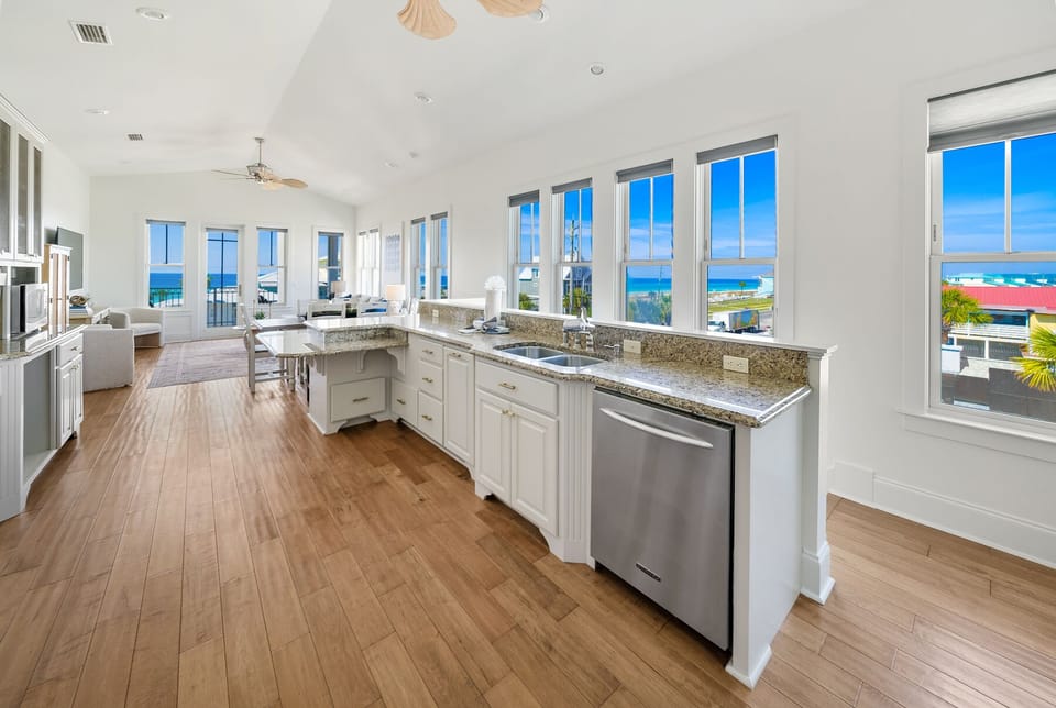 Cook your favorite meals while enjoying breathtaking ocean views through floor-to-ceiling windows in this bright, open kitchen.