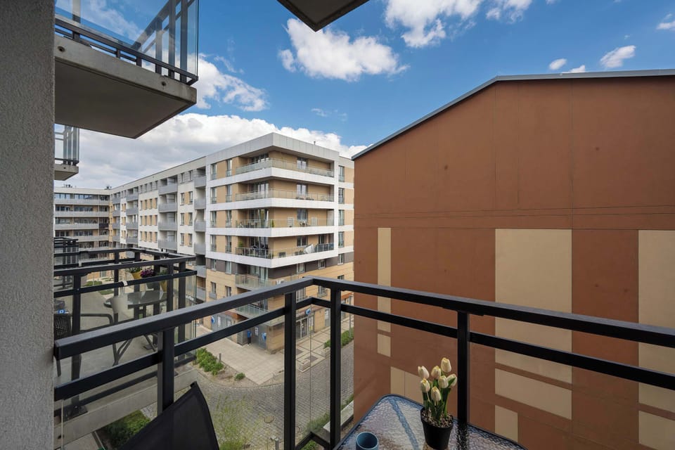 An alternative angle of the balcony shows the black railing and the contrast between the building's orange and grey facades.
