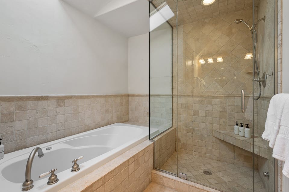 Large soaking tub with tiled step in shower, double vanity and water closet is all you need for a relaxing evening after many adventures.