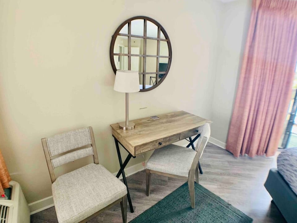 Transform the bedroom into a coastal vanity haven, where a mirror and a chair create a serene space for personal rituals with an ocean view.