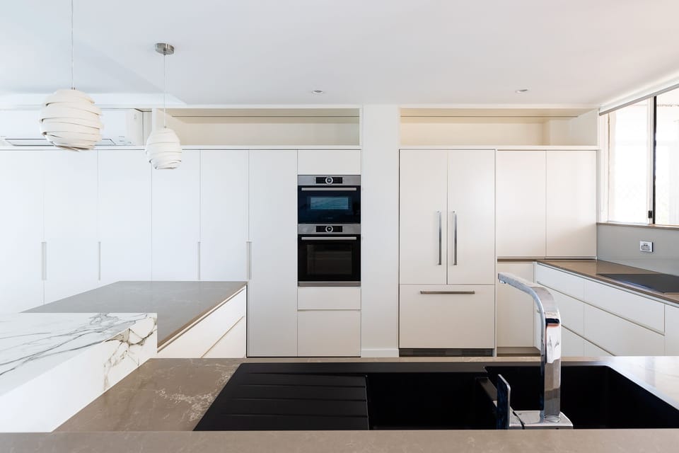 Sophisticated open plan Bosch kitchen with chic stone benchtops