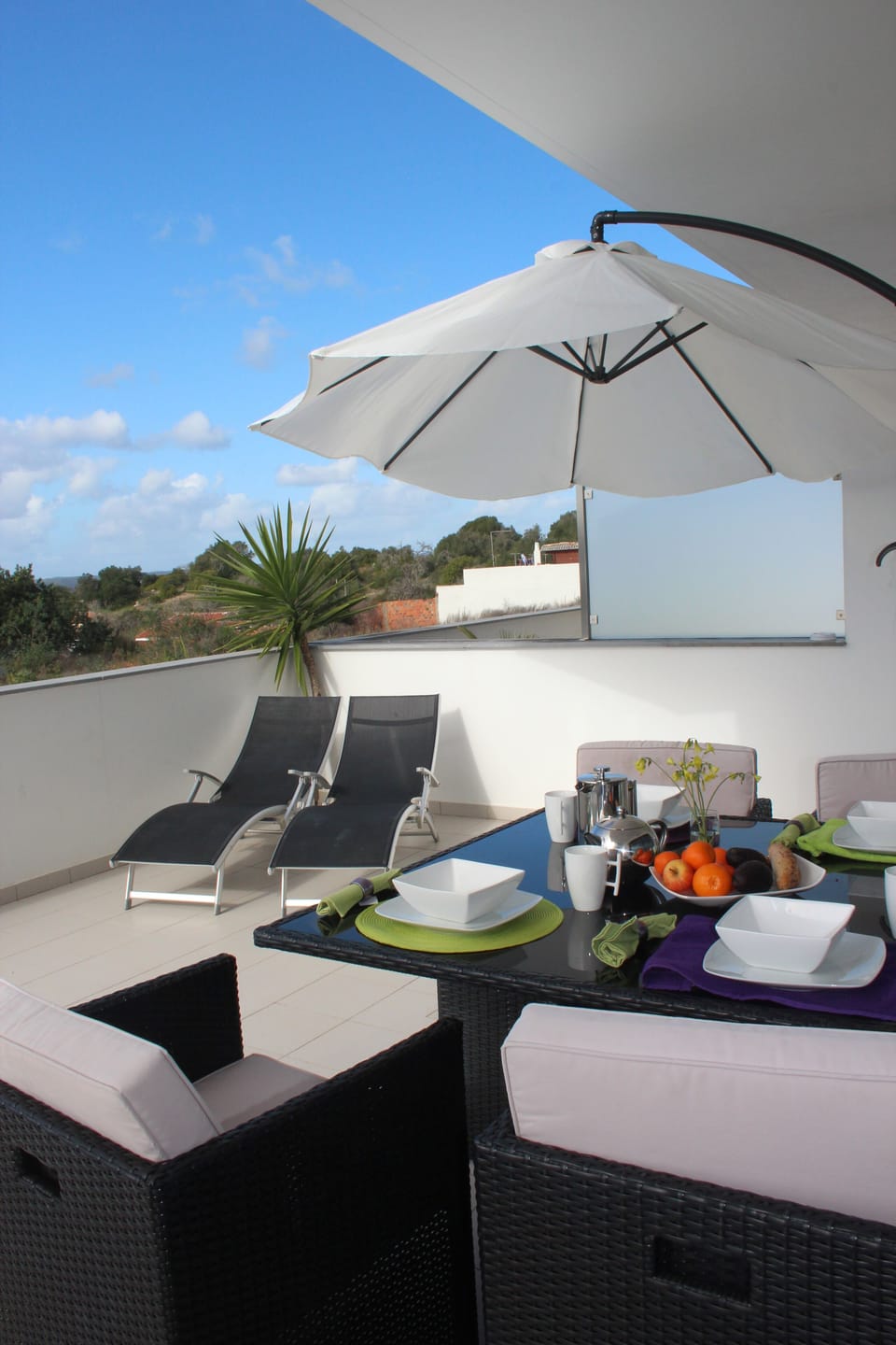 Main terrace with dining, sun loungers and direct access to pools and garden