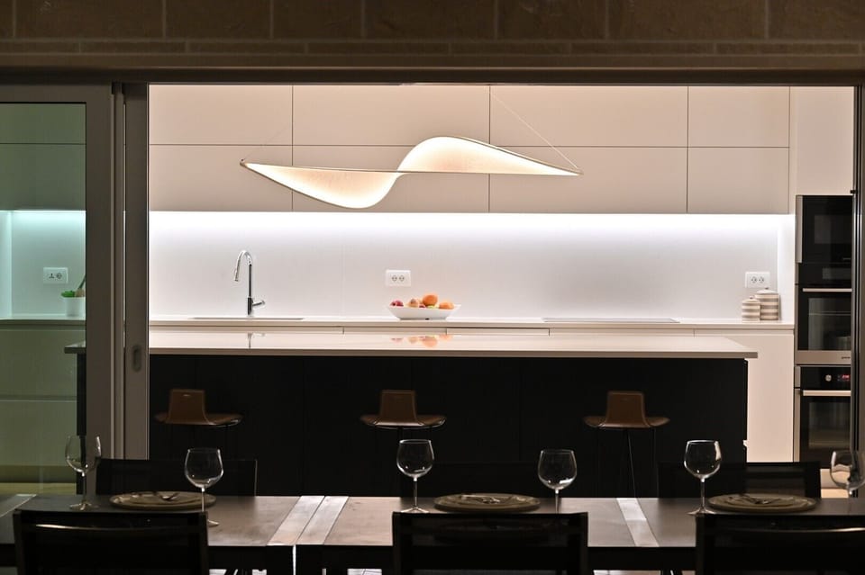 Modern kitchen with kitchen island and direct entrance to the terrace of the beachfront villa with wine cellar 