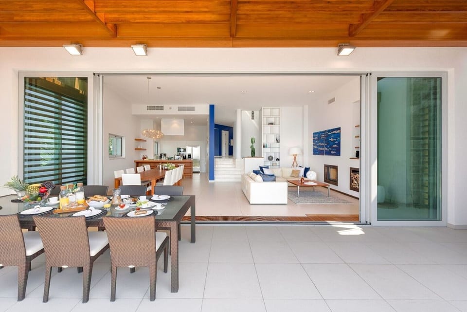 View from the terrace of the living room with dining room and modern kitchen of a private vacation villa with pool in Brela