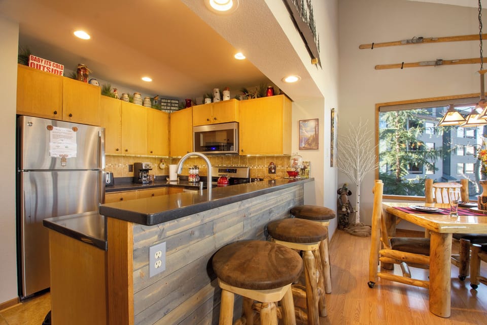 Your fully equipped kitchen invites cooking adventures with warm wood cabinets, modern appliances, and a breakfast bar for casual dining.