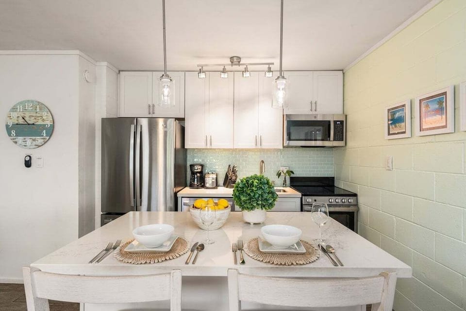 Modern kitchen with stainless appliances, white cabinetry, and a clean, airy layout perfect for effortless island meals.
