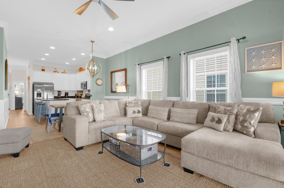 Spacious open-concept living room featuring a large sectional, perfect for relaxing or entertaining guests.