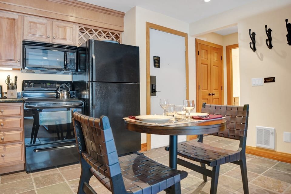 The dining area has seating for two around the pedestal table