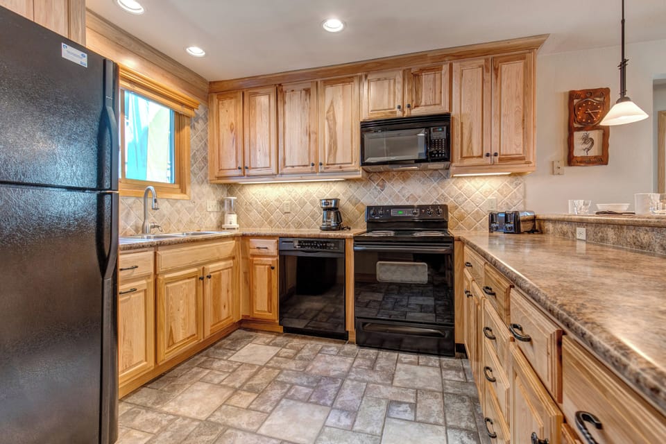 Snow Flower 20 offers a well-equipped kitchen with black appliances and breakfast bar.