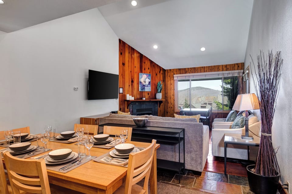 Snow Flower 29's open concept dining area and living area with vaulted ceilings, recessed lighting and white and wood walls.