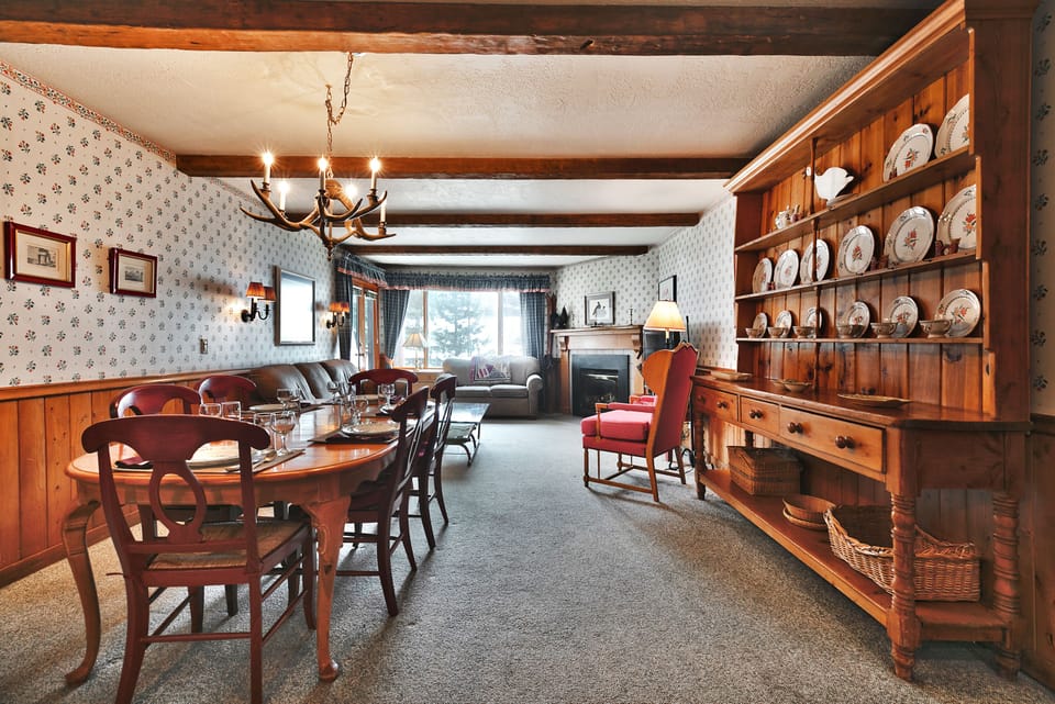 Dining area opens into the living room and features an antler chandelier
