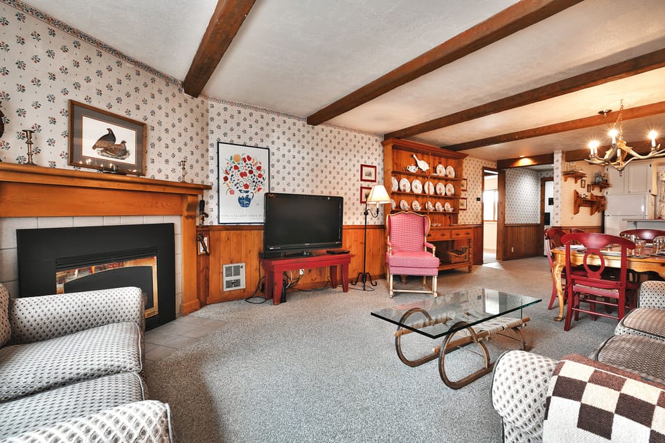 Living room has comfortable seating on a couch, love seat and red rocking chair
