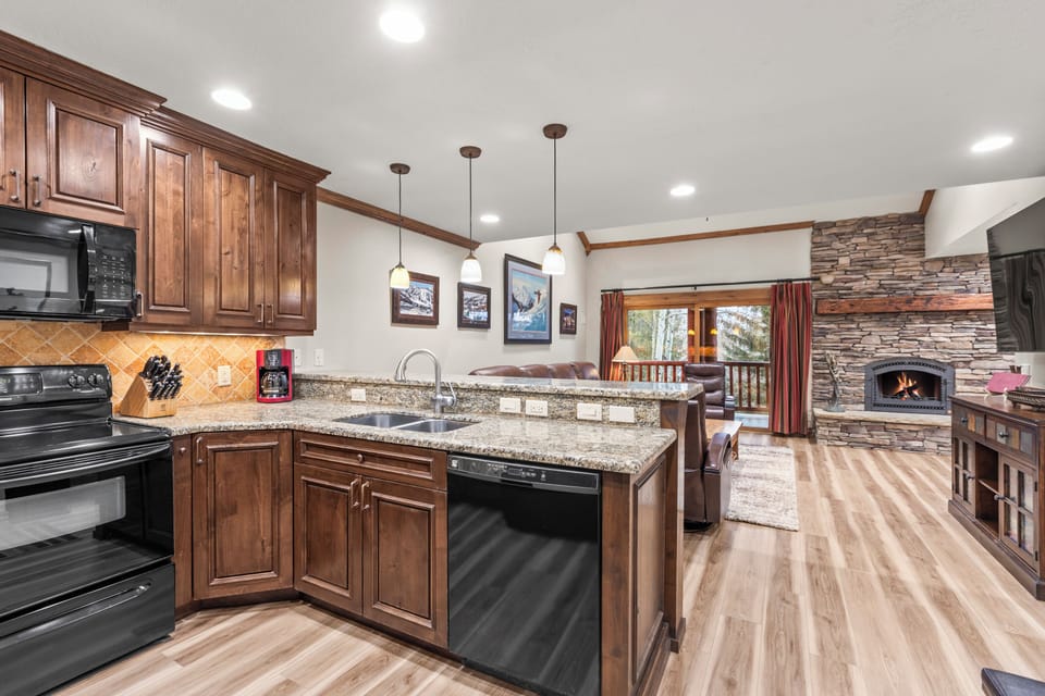 Your spacious kitchen features granite countertops, rich wood cabinets, and a cozy stone fireplace.
