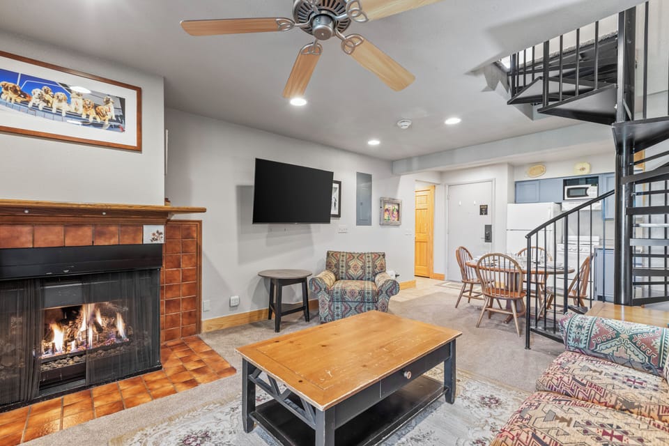 Snow Flower 72's living room with fireplace, flat screen TV, and open concept open to the dining and kitchen area.