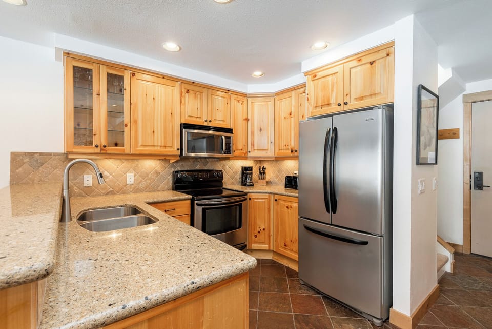 Stainless steel appliances in the kitchen and additional seating at the breakfast bar.