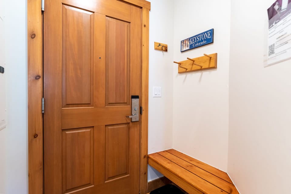 Your private entrance welcomes you with warm wood details and a cozy bench for settling in.