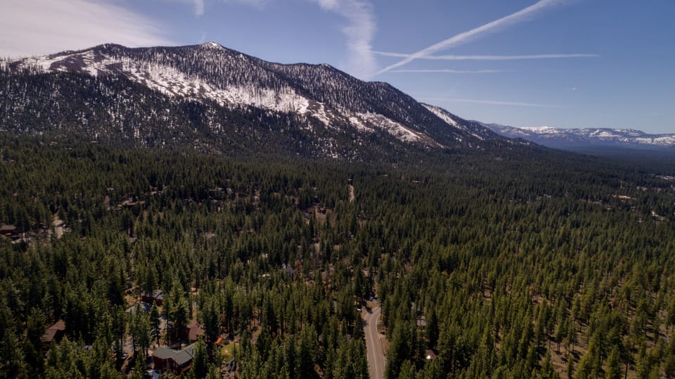 Breathtaking aerial view of the surrounding forest and majestic mountain peaks
