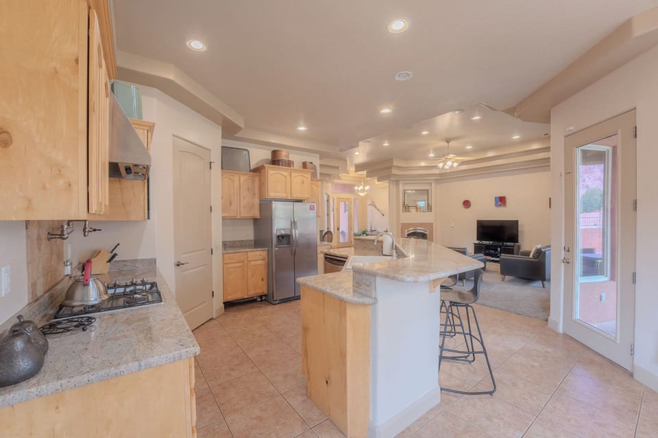 Spacious kitchen with granite island flows into the living room at this Kanab vacation rental, Spirit of the Rock.
