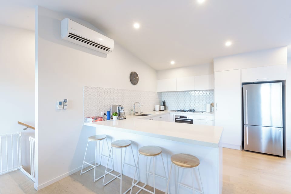 Kitchen with lots of bench space for cooking and breakfast bar; forest views