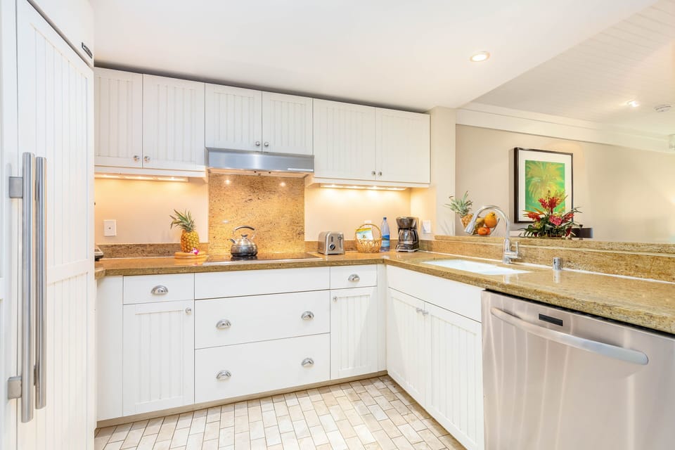 The kitchen with white cabinets and granite countertops.